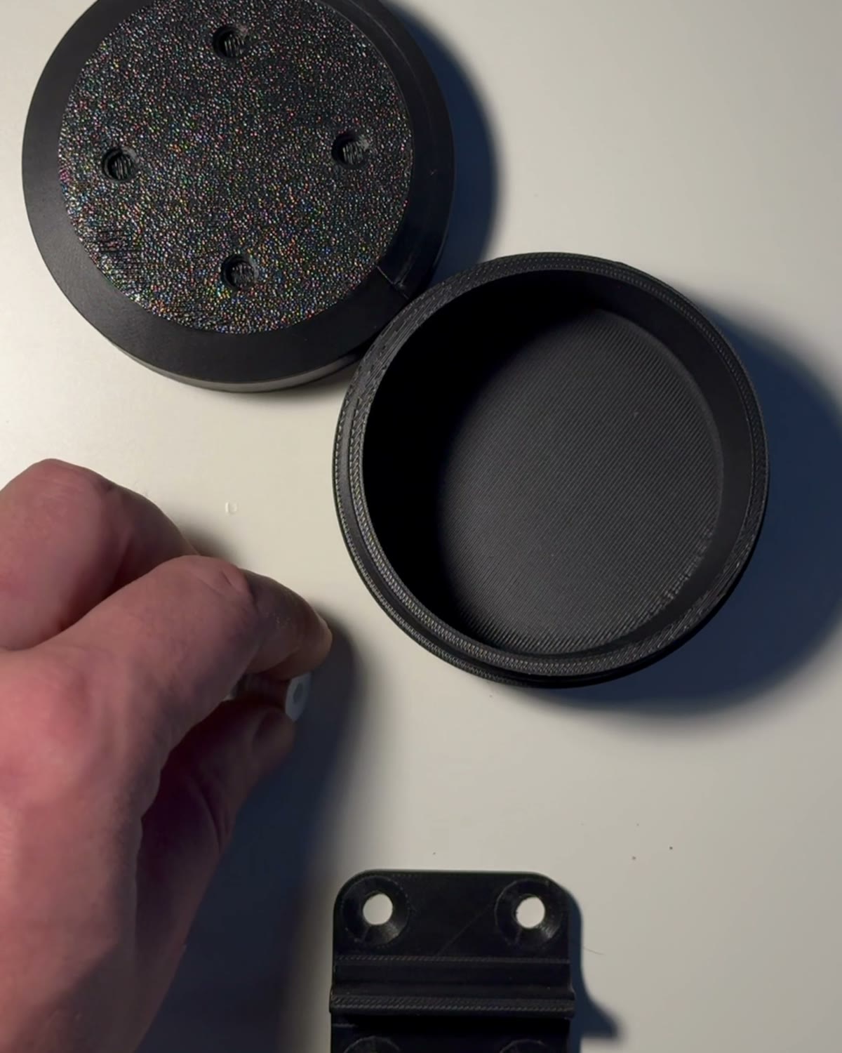 Printed box, lid, SI3DP screws and a bracket laid out on a table